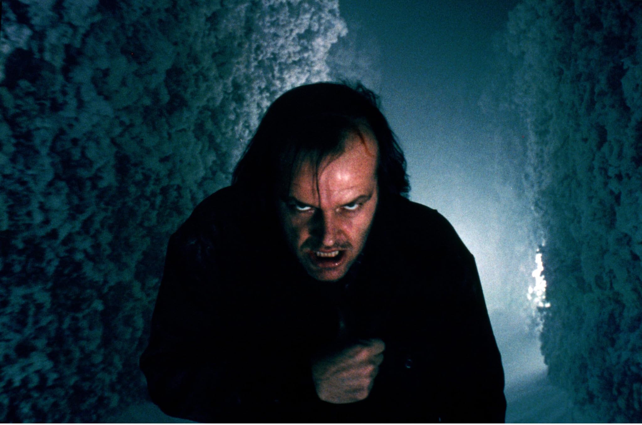 Jack Torrance lunges through a snow-packed corridor while the walls close in.
